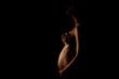 belly of pregnant woman on a dark background