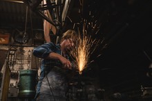 Blacksmith Grinding A Metal Rod With Grinder Machine