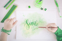 Boy Writing The Word Smile With Watercolor Paint