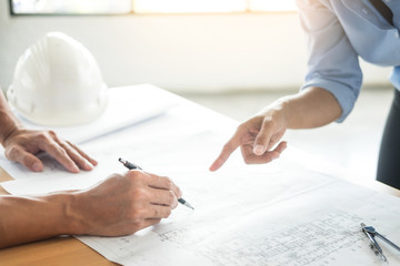 Close-up Of Person's engineer Hand Drawing Plan On Blue Print with architect equipment, Architects discussing at the table, team work and work flow construction concept