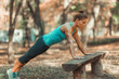 © Microgen - Woman doing push ups in the park, in the fall.