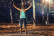 © Microgen - Woman Exercising With Elastic Band Outdoors in The Fall