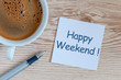 Happy Weekend message at peace of paper on office desk with morning coffee cup