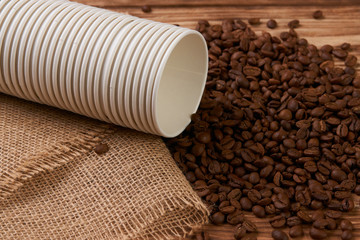 Take away Coffee paper cup and coffee beans on wooden background, close-up