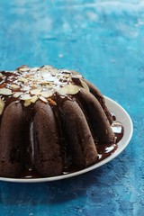 Poster - Homemade chocolate  bundt cake on blue wooden background, selective focus