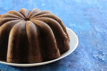 Poster - Homemade chocolate  bundt cake on blue wooden background, selective focus