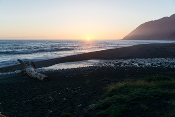 Wall Mural - A colorful beach sunset over the black sands of the Lost Coast backpacking trail in California