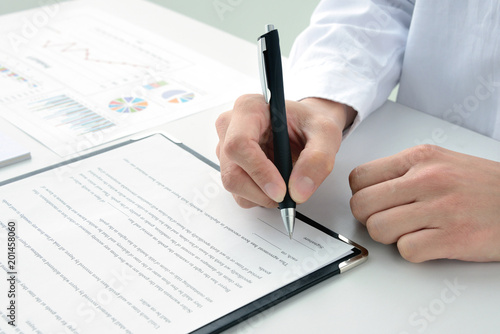 Photographie  契約書にサインする女性の手