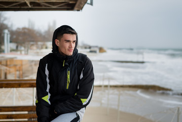 guy sportsman resting after jogging near the ocean