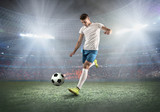 Fototapeta Sport - Soccer player on a football field in dynamic action at summer da