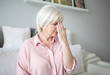 © innervisionpro - Senior lady with migraine touching her forehead