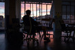 © StudioWout - Man sitting on chair working late in office at dusk
