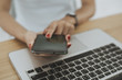 © pixindy - Woman hand with computer laptop on wood table.
