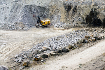 Excavator works quarrying extraction of aluminum ore. heavy machinery