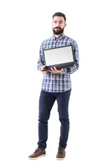 Confident young bearded programmer showing blank empty laptop monitor. Full body isolated on white background. 