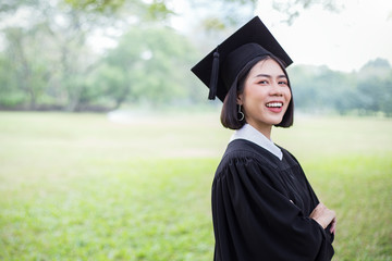 Portrait of young asian woman outside the building on her graduated day. Cute asian girl with her hands holding certificate paper, Education success graduate concept