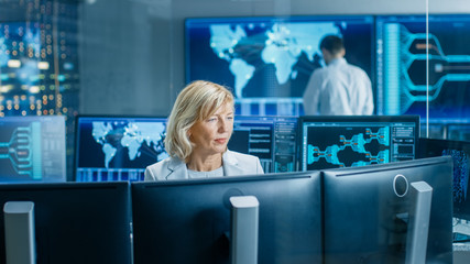 Leinwandbilder - System Monitoring Room Professional Female Operator Observes Correct Functioning of the Facility. In the Background People Working with Interactive Map.