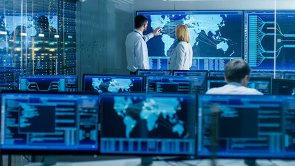 Leinwandbilder - In the System Monitoring Room Two Senior Operators Work on a Big Interactive Map. Facility is Full of Screens Showing Technical Data.