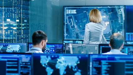 Leinwandbilder - In the Government Surveillance Facility Team of Officers Organize Interception Plan with Help of Satellite Navigation. Big Screen Shows Top Down Images of the Target.