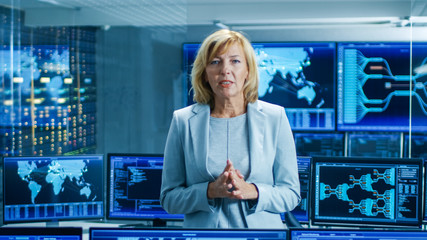 Leinwandbilder - In the System Control Room Female Chief Engineer Describes Her Project Talking into the Camera. In the Background Multiple Screens Showing Interactive Data.