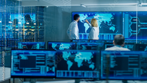 Cuadros en Lienzo In the System Monitoring Room Two Senior Operators Work on a Big Interactive Map