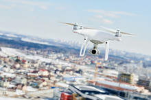 Drone Quadcopter With Digital Camera Hovering Over City