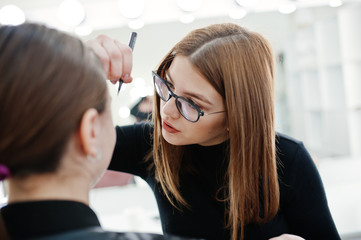 Wall Mural - Make up artist work in her beauty visage studio salon. Woman applying by professional make up master. Beauty club concept.