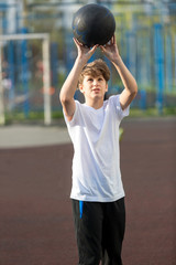 cute young sporty boy in white t shirt plays basketball on his free time, holidays, summer day. Sport  health lifestyle concept