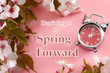© Victor Moussa - Turn clocks on hour ahead, star of daylight savings time change and reminder to spring forward concept with clock on pink background with springtime flowers and text - Don't forget to spring forward