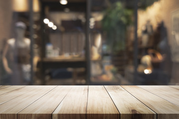 Wall Mural - Wooden table with blur background of coffee shop.