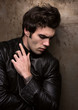 © Bakulov - Portrait of a stylish man in a black leather jacket near wall