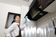 台所の換気扇を掃除している主婦