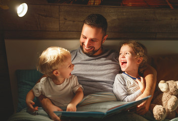 evening family reading. father reads children . book before going to bed