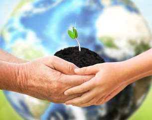 The man holding tiny plant with baby over planet Earth backgroun