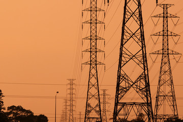 Wall Mural - high voltage poles on the orange sky concept of electric power