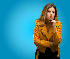 Wall Mural - Beautiful young woman scared in shock, expressing panic and fear, blue background