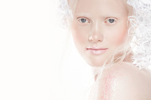 A Very Delicate Portrait Of An Albino Girl, A White Background, Snowflakes In Her Hair, Sparkles, A Magical Winter Image. Natural Make-up, Pink Lipstick On Lips.