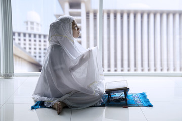 Muslim woman prays to the Allah at home