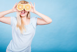 Fototapeta Młodzieżowe - Girl covering her eyes with grapefruits