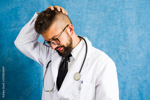 Fotografía Portrait of a worried doctor against blue background