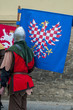 Back view of man wearing medieval costume and steel helmet holding flag. Actor during festival in Czech Republic, Europe