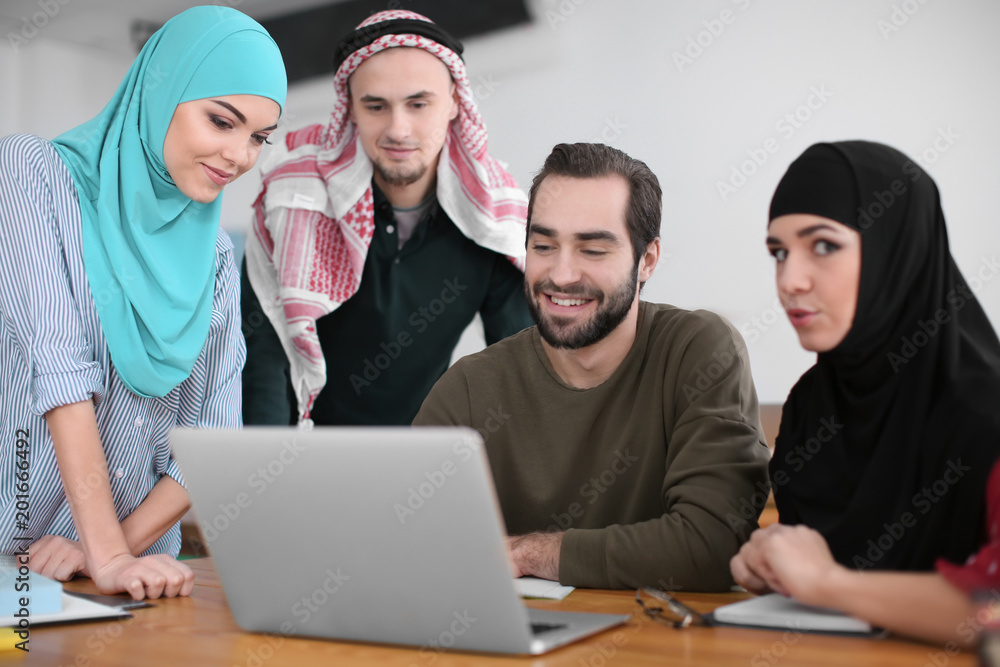 Male student and his Muslim classmates in library