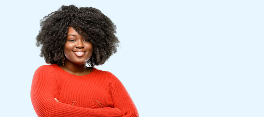 Poster - Beautiful african woman with crossed arms confident and happy with a big natural smile laughing, blue background