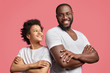 © wayhome.studio  - Positive dark skinned male with shining smile keeps hands crossed stands back to attractive African American teenager, have good intention, isolated over pink background. Friendship concept.