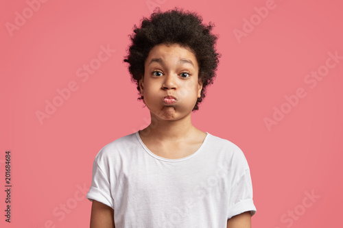 Portrait Of Small Mixed Race Male Kid Blows Cheeks And Puffs