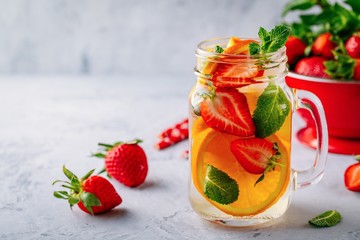 Wall Mural - Infused detox water with orange, strawberry and mint. Ice cold summer cocktail or lemonade.