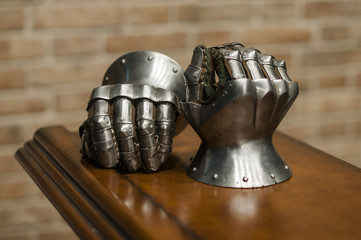 Medieval armor, detail of an ancient armor. Steel gloves on wooden background.