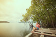 © Cincinart - Traveling girl on the wood pier. Pretty young woman and tropical landscape. Summer lifestyle and adventure photo. Fish eye lens image