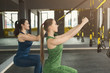 Women performing suspension training in gym
