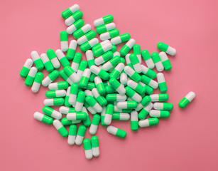 Pile of red capsules of pills on a pink background top view. Medicine Health Pharmacy Pharmacology Concept